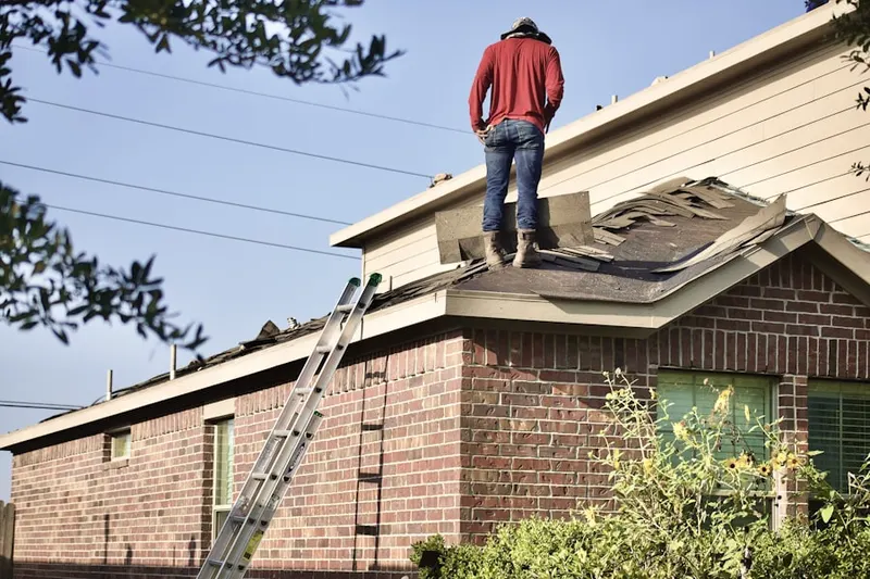 Professional roofer working on a residential roof in Pootatuck Park